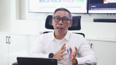 Petugas ukur tanah melakukan pengukuran di lapangan.